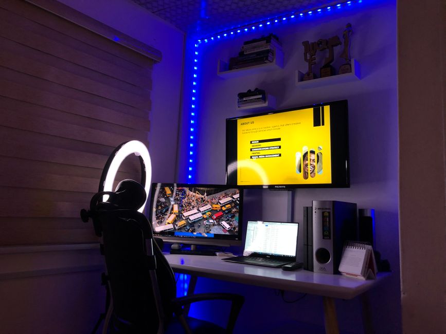 A stylish home office setup featuring dual monitors and ambient lighting, perfect for productivity and relaxation.